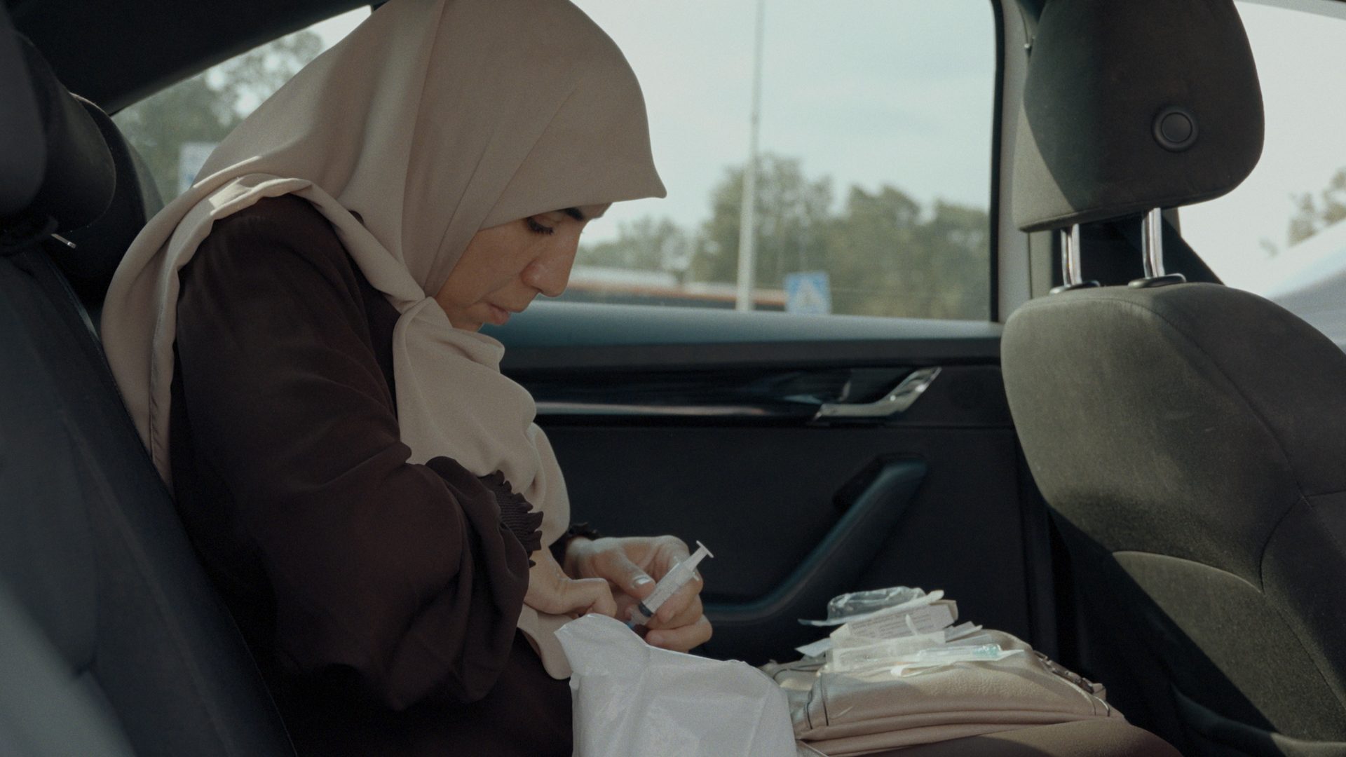 A woman preparing a syringe — still from FOR LIFE